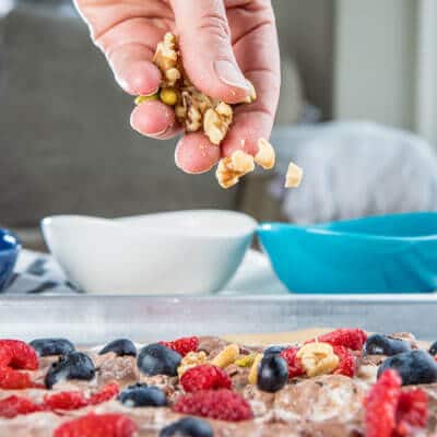raspberries, blueberries, and chopped nuts on top of the ice cream layer